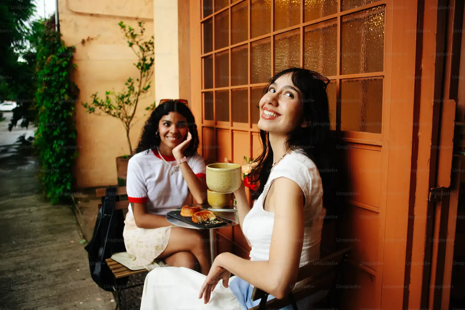 Two friends laughing outside a café