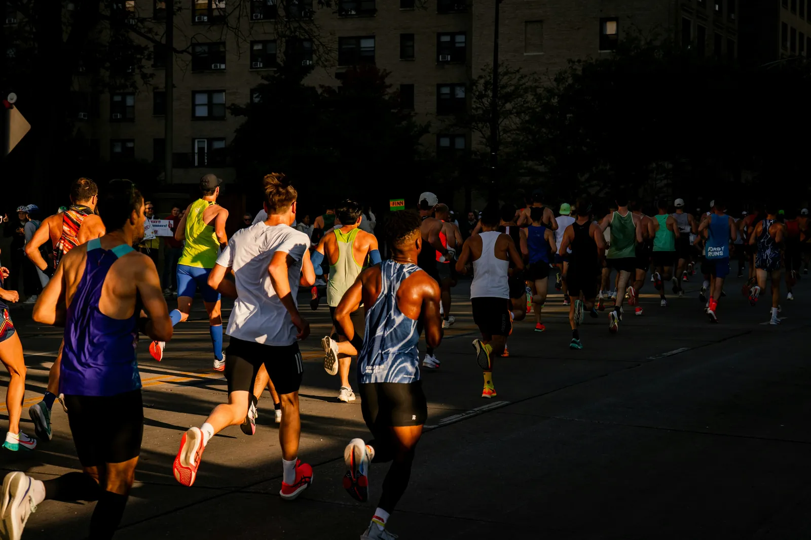 A group of runners on a city street in the evening