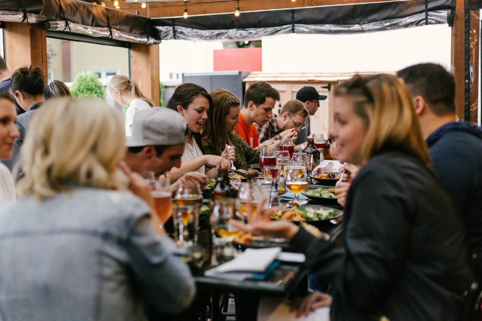 A long outdoor dinner table full of friends
