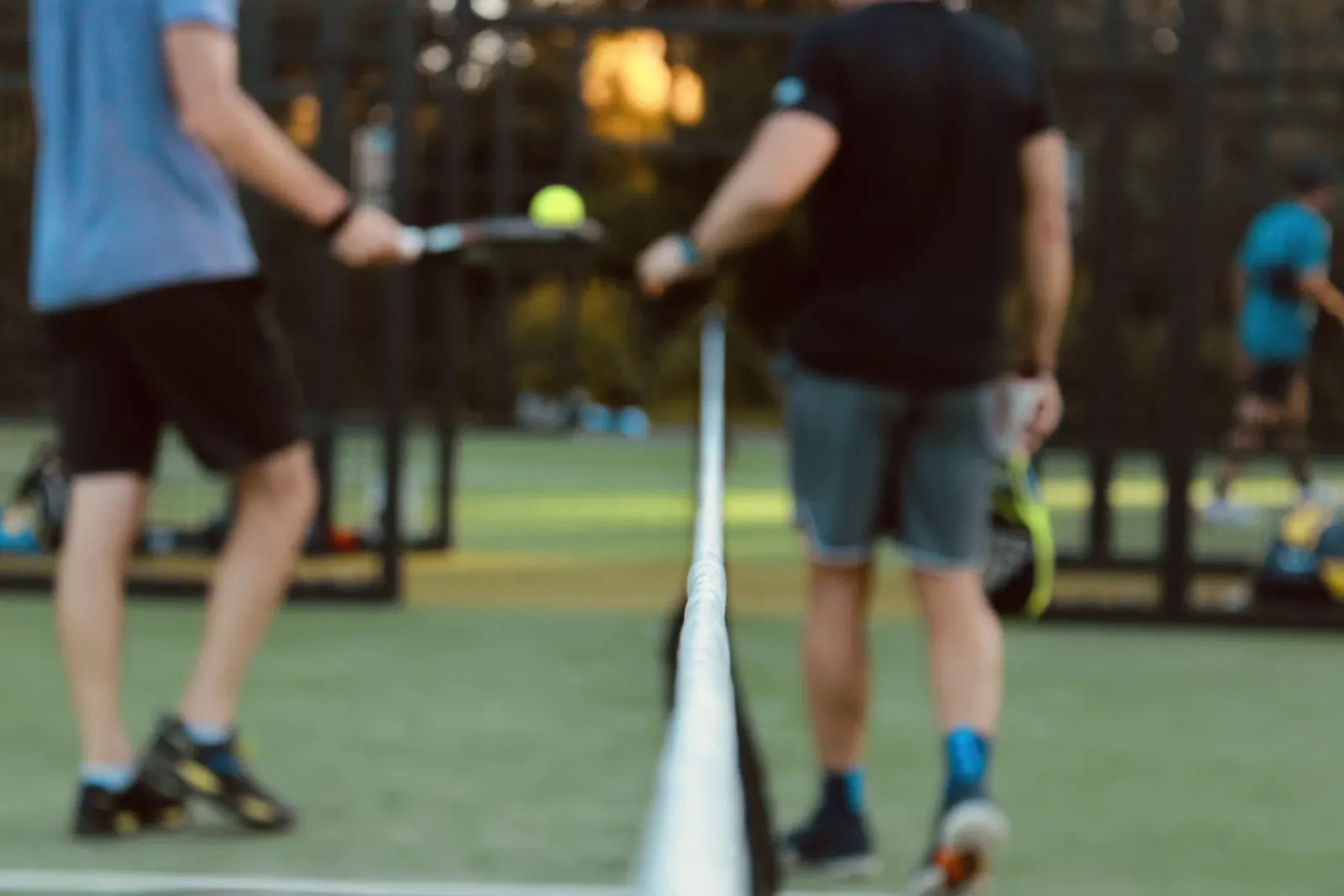 Two people playing tennis at the net